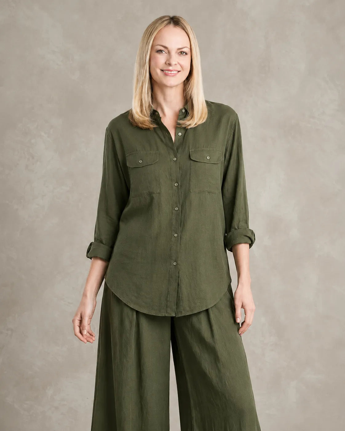 Een dichterbij vooraanzicht van een model in de legergroene linnen co-ord set, met de borstzakken en knoopsluiting van de blouse.