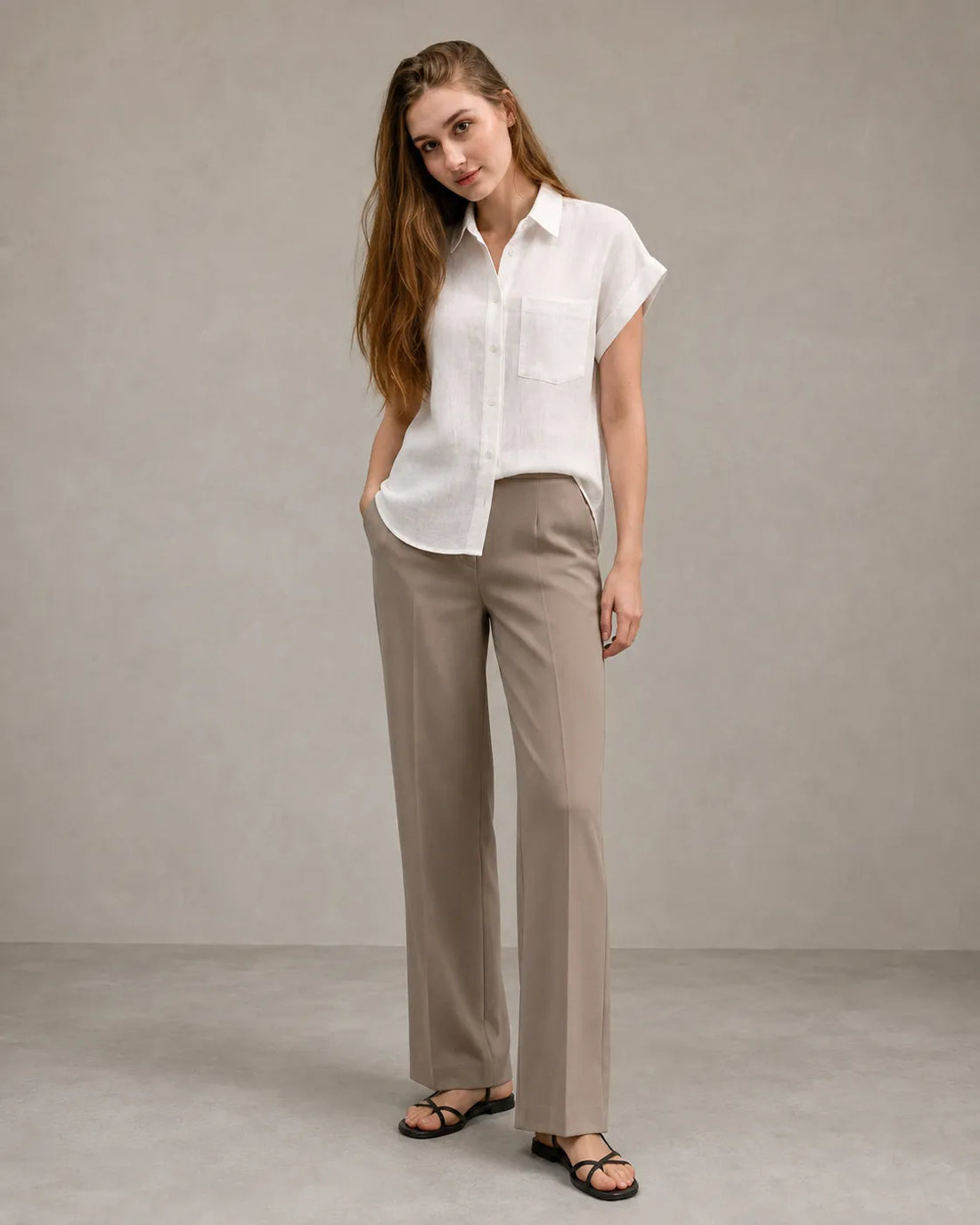 Woman wearing a well-pressed off-white linen shirt with a polo collar, styled with tailored trousers, illustrating properly cared-for linen clothing.