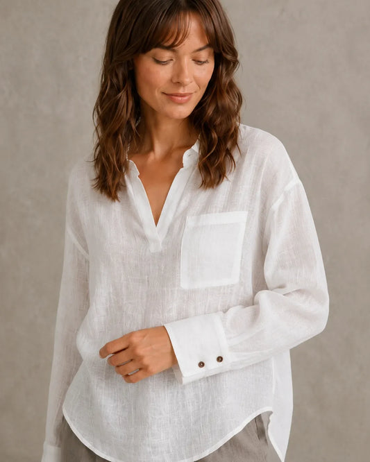 Close-up of the button cuff detail on a white linen shirt, showing crisp, well-ironed fabric.