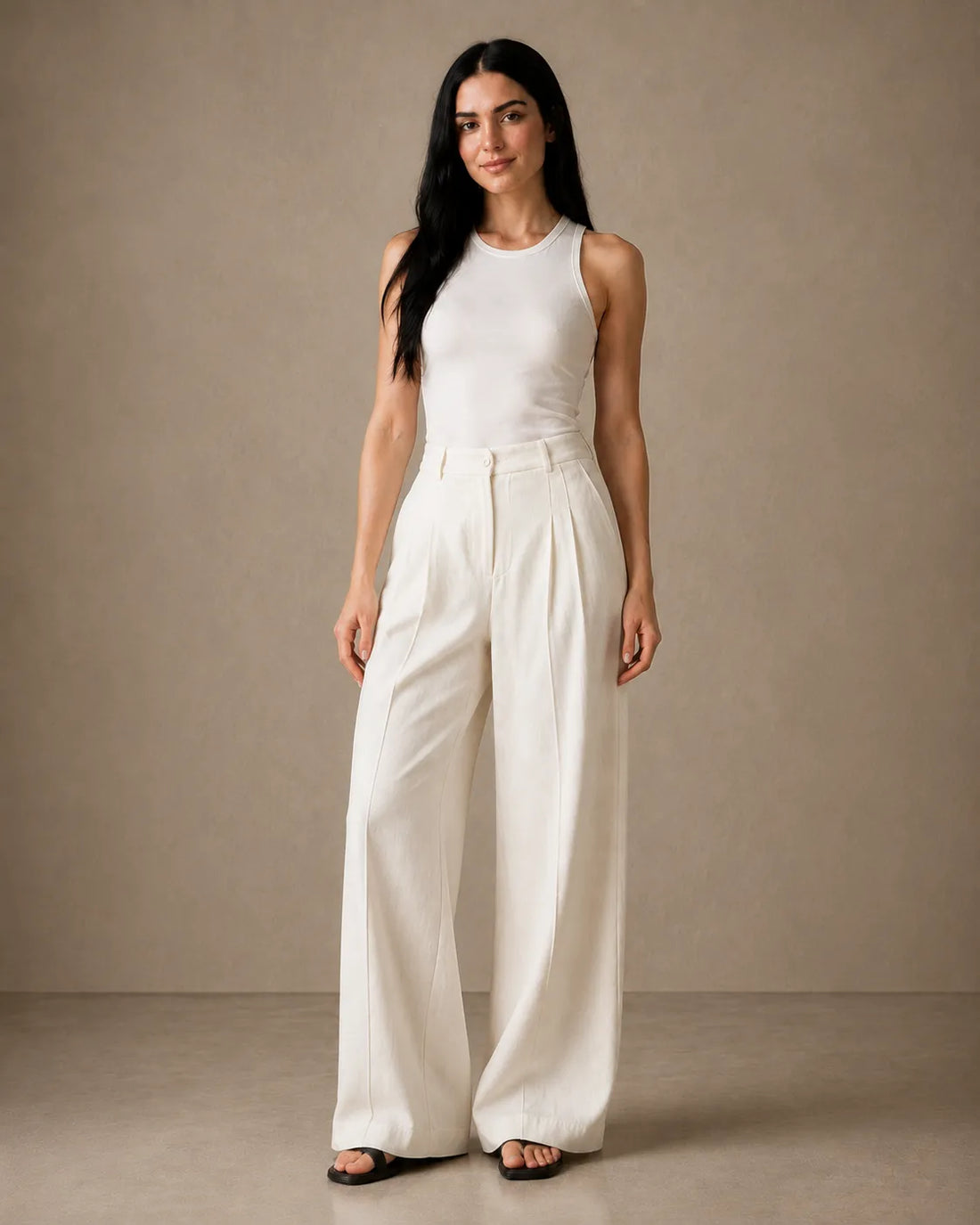 Close-up of a woman wearing oatmeal-white wide-leg trousers in a linen-tencel-viscose blend, a checklist-worthy capsule wardrobe piece.