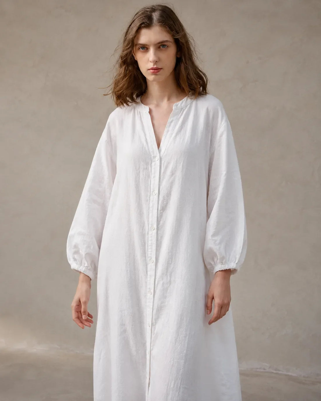 Close-up of the long balloon sleeves and elasticated cuffs on a white cotton-linen dress.