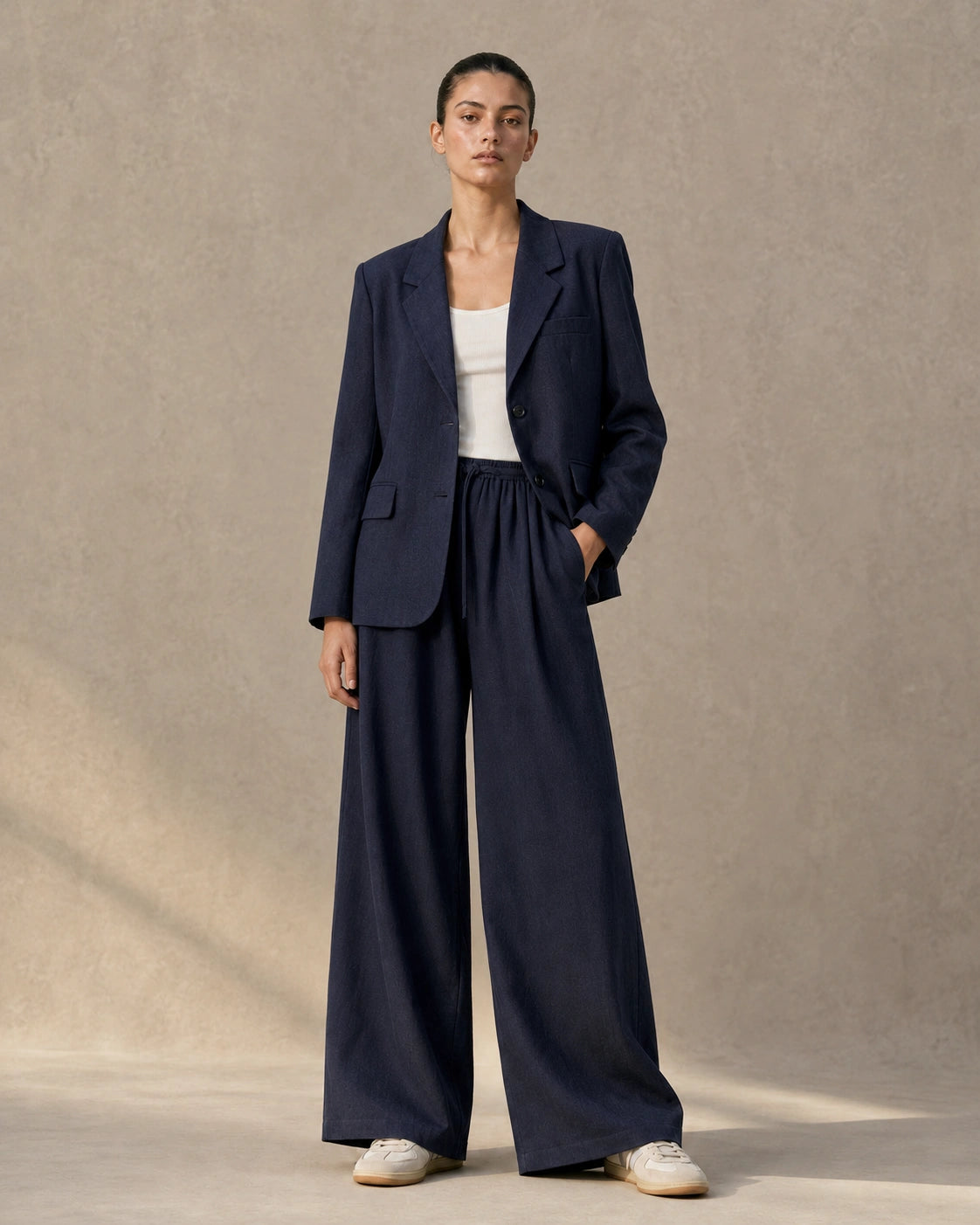 Model wearing an apricot tencel-linen blazer and tailored trousers co-ord set, front view.
