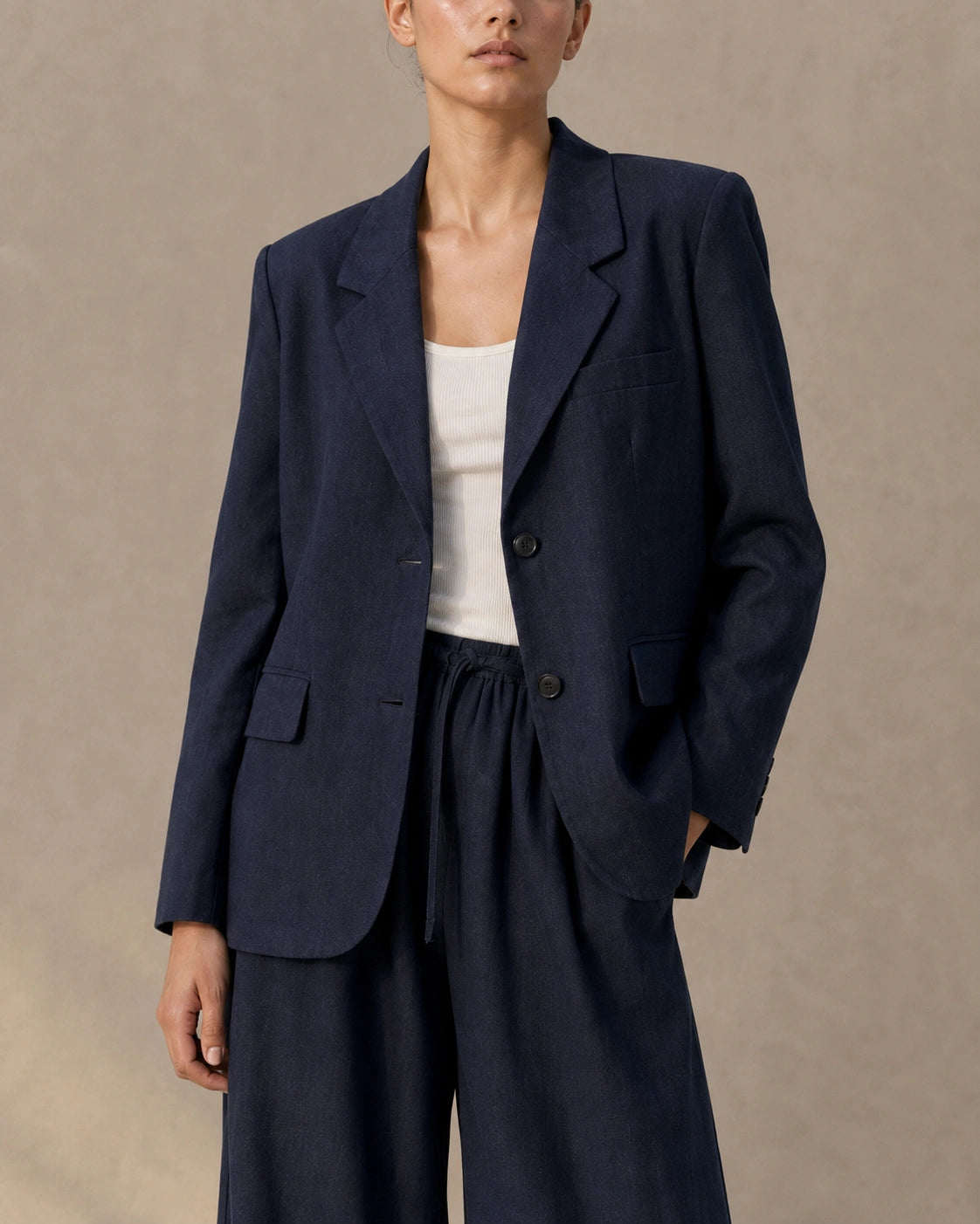 Front view of a model wearing a navy tencel-linen blazer and matching tailored trousers as a co-ord set, cropped at the torso.