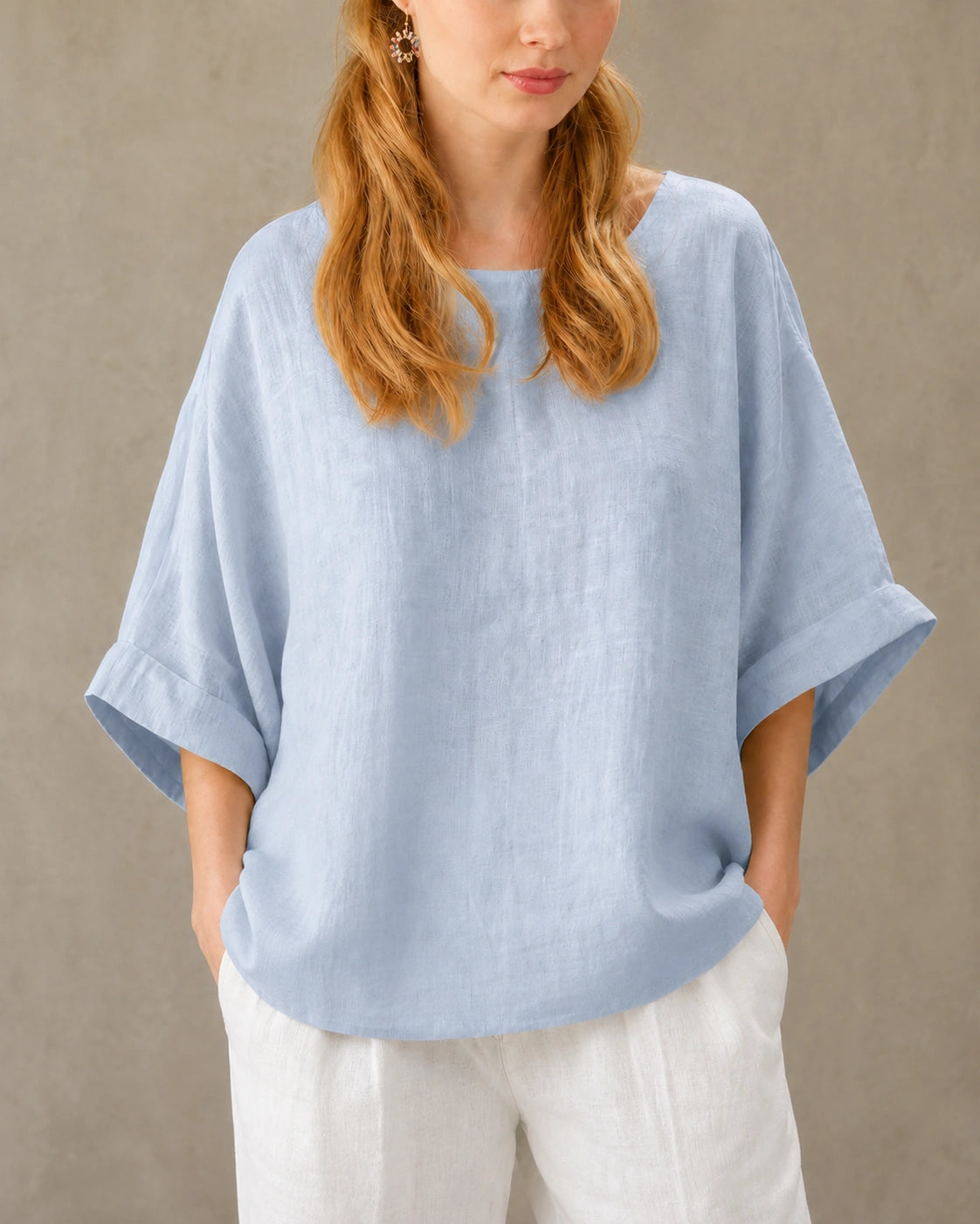 Close-up van de valschoudernaad en driekwart mouw van een blauw bamboe-hennep blouse.