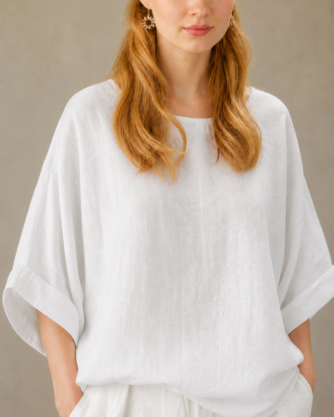 Close-up van de valschoudernaad en driekwart mouw van een wit bamboe-hennep blouse.