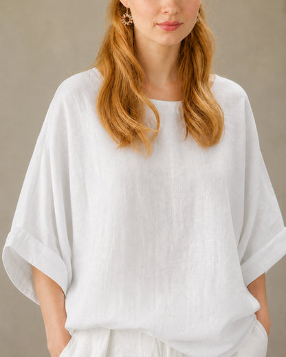 Close-up van de valschoudernaad en driekwart mouw van een wit bamboe-hennep blouse.