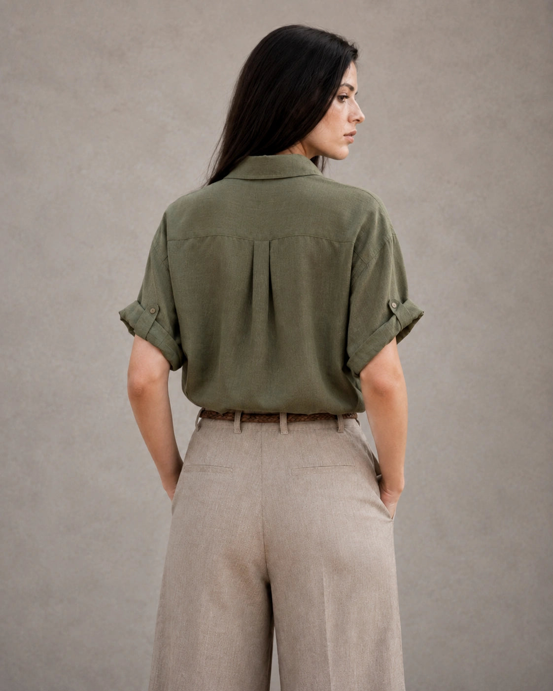 Achteraanzicht van een groen katoen-linnen blouse met korte, omgeslagen mouwen.