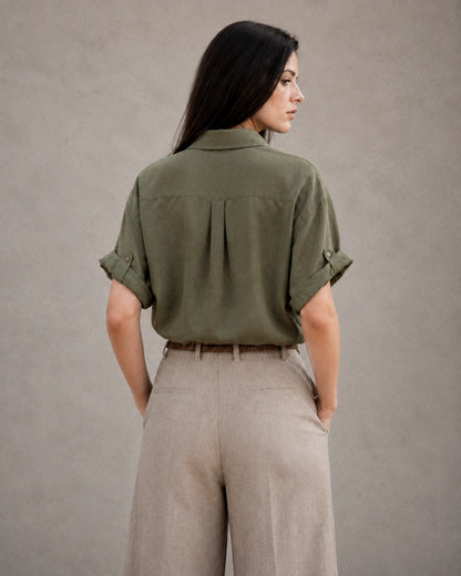 Achteraanzicht van een groen katoen-linnen blouse met korte, omgeslagen mouwen.