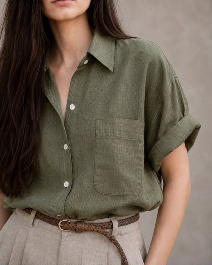 Close-up van de borstzak en knopenlijst van een groen katoen-linnen blouse.