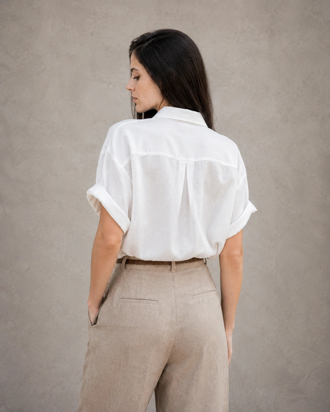 Achteraanzicht van een wit katoen-linnen blouse met korte, omgeslagen mouwen.