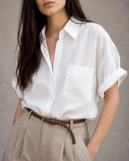 Close-up van de borstzak en knopenlijst van een wit katoen-linnen blouse.