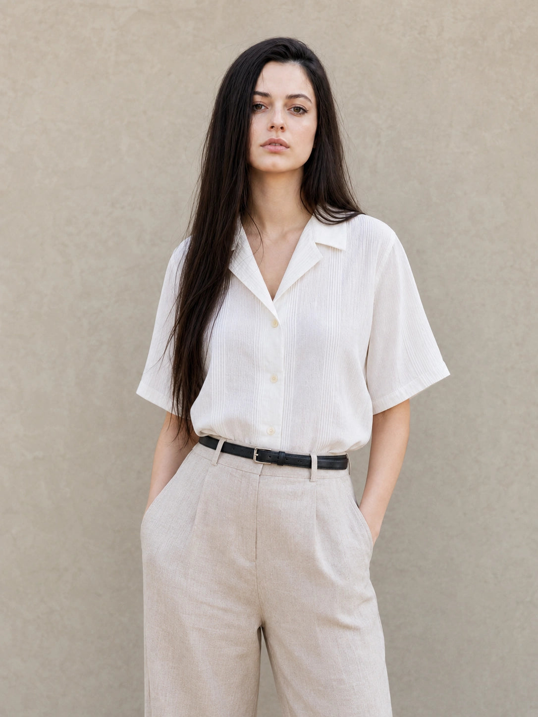 Vrouw draagt een witte blouse met Cubaanse kraag en korte mouwen, vooraanzicht.