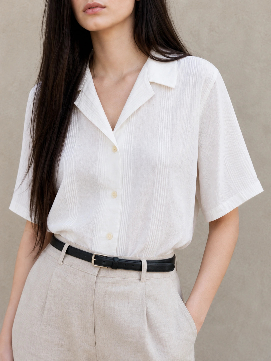 Close-up van de open Cubaanse kraag van een witte katoen-polyester blouse.