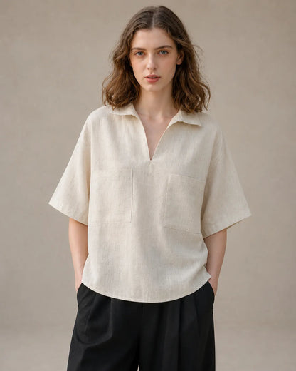 Woman wearing an oversized linen beige V-neck shirt with short sleeves, viewed from the front.
