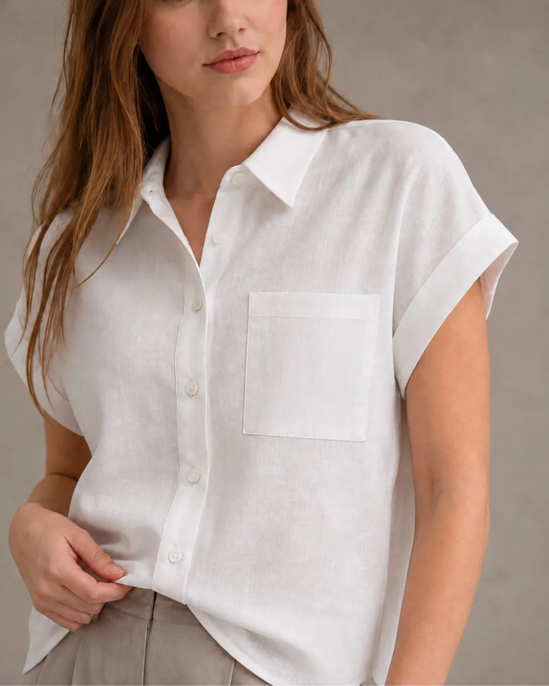 Close-up of the chest pocket and collar on a off-white linen shirt.