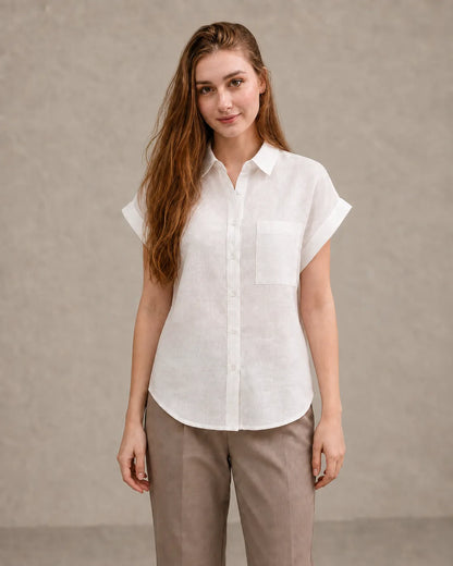 Woman wearing a off-white linen shirt with a polo collar and short sleeves, viewed from the front.