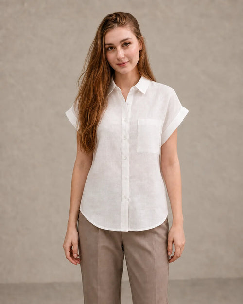 Woman wearing a off-white linen shirt with a polo collar and short sleeves, viewed from the front.