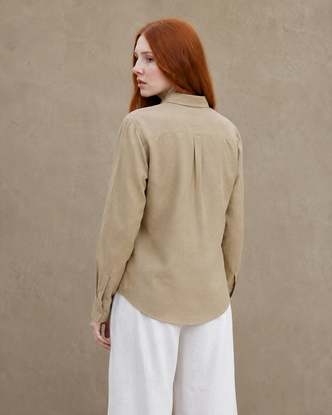 Achteraanzicht van een kaki linnen blouse met getailleerde kraag en lange mouwen.