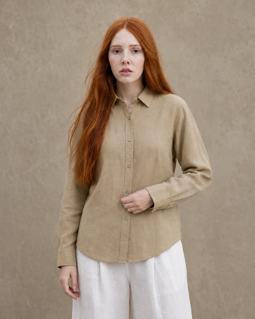 Vrouw draagt een kaki linnen blouse met getailleerde kraag en lange mouwen, vooraanzicht.
