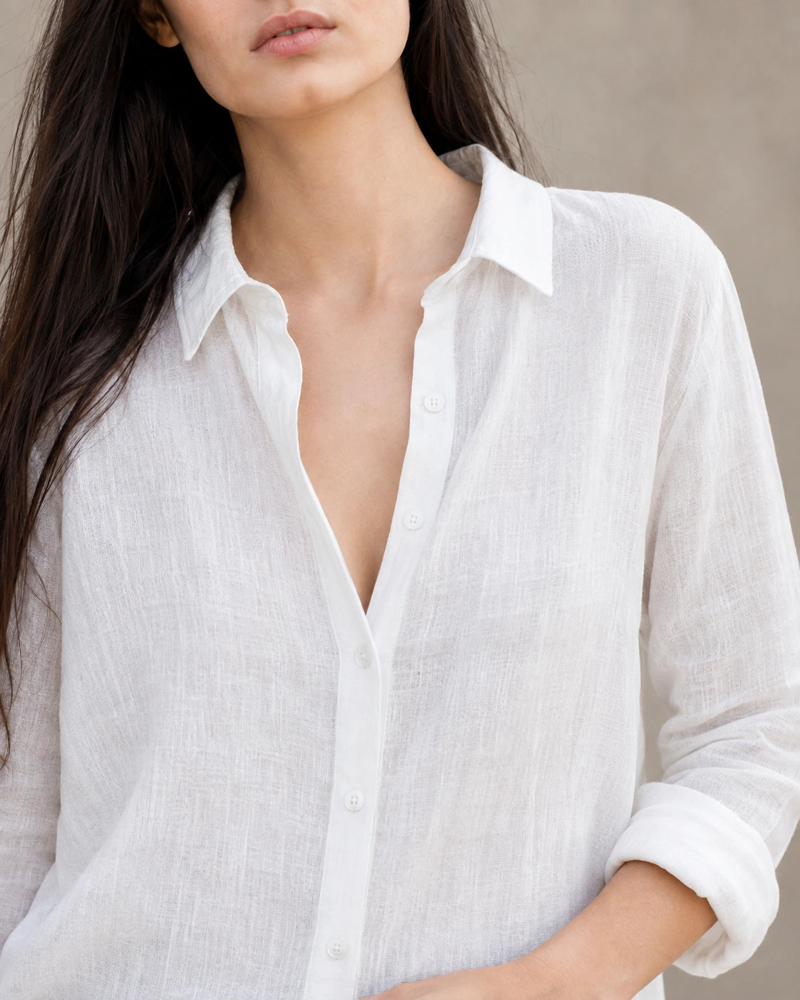 Close-up van de open kraag en halslijn van een losse wit linnen-katoenen blouse.