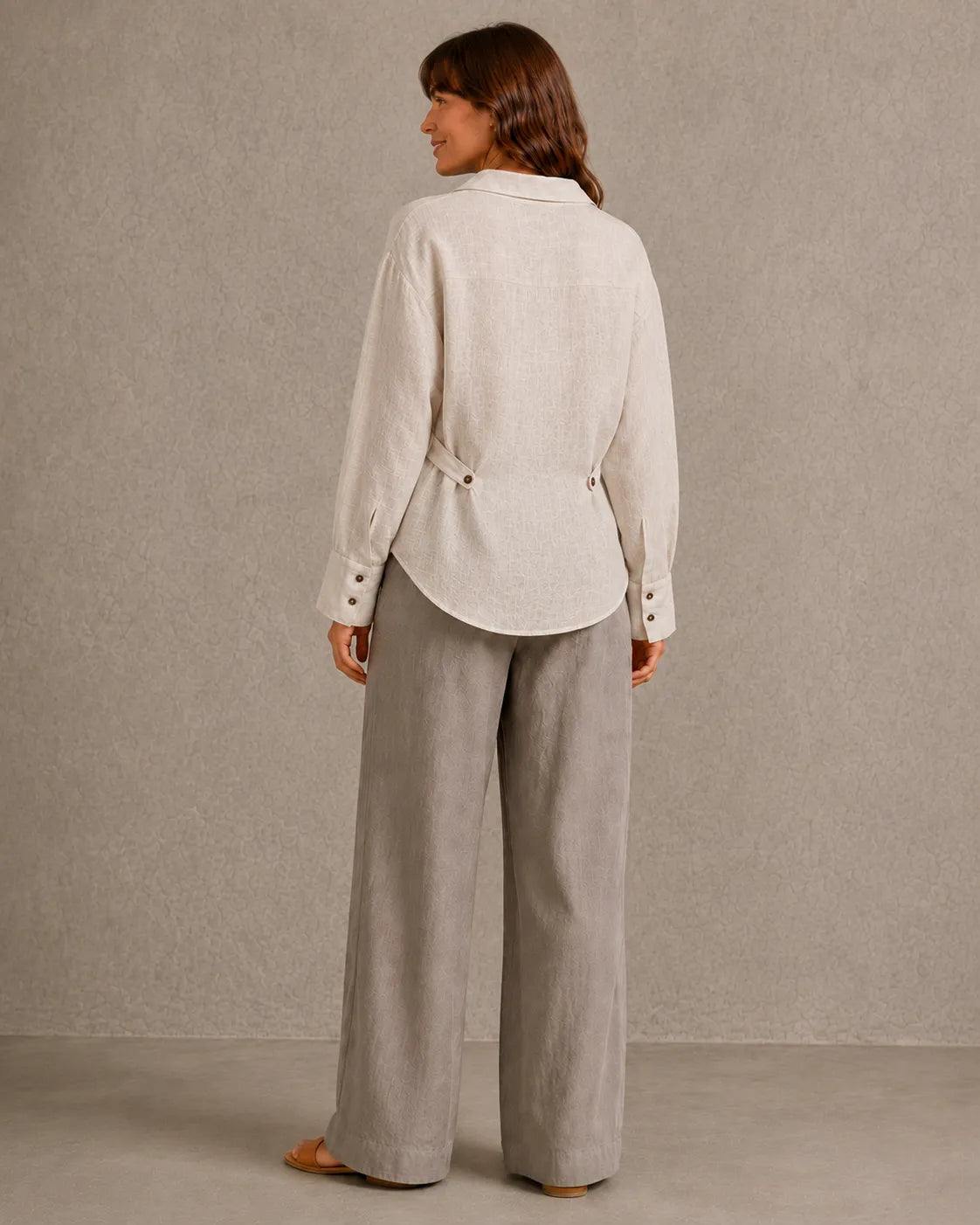 Achteraanzicht van een naturel linnen blouse met lange mouwen en getailleerde taille.