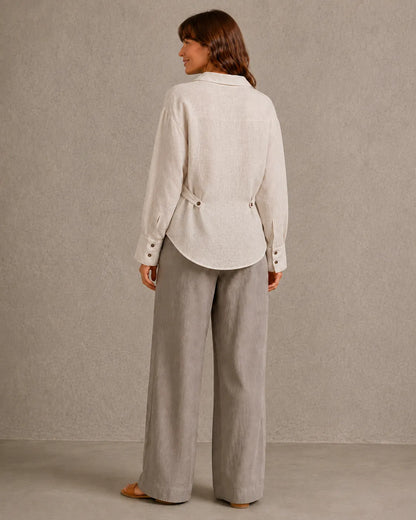 Achteraanzicht van een naturel linnen blouse met lange mouwen en getailleerde taille.