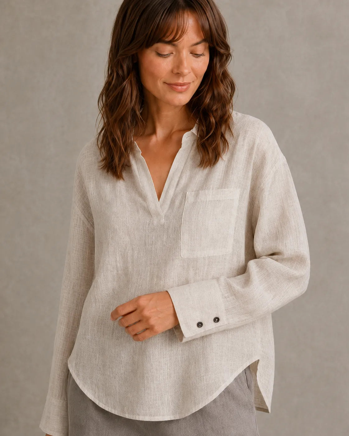 Close-up van de manchetknoop en borstzak van een naturel linnen blouse.
