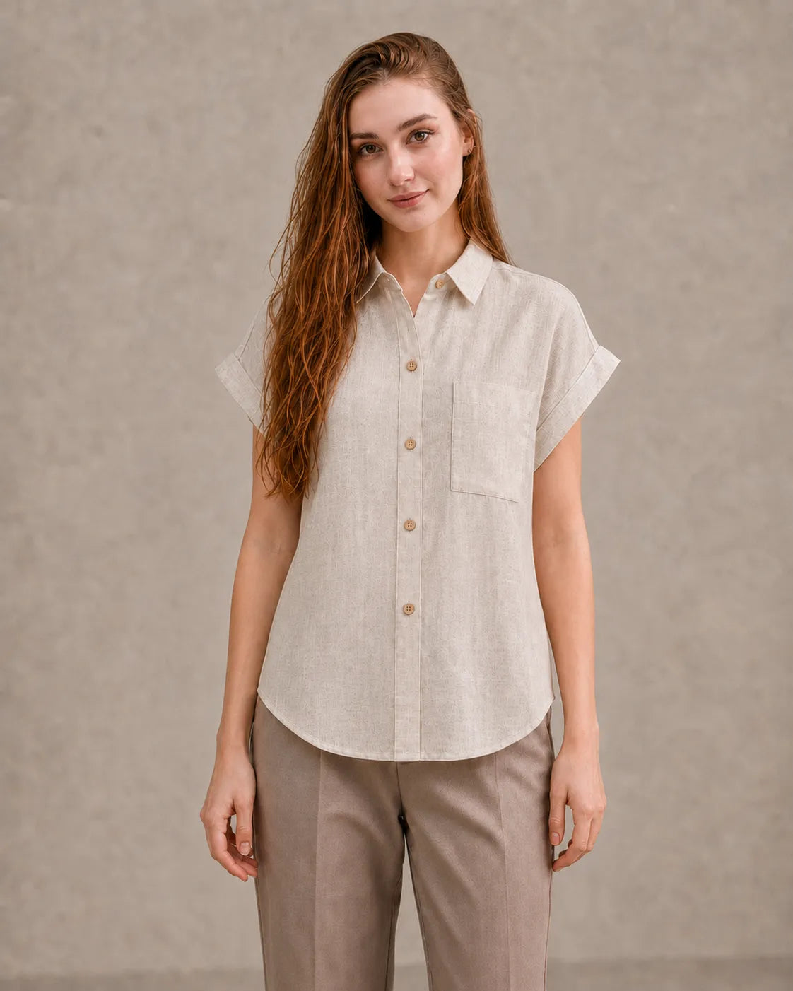 Woman wearing a natural undyed linen shirt with a polo collar and short sleeves, viewed from the front.