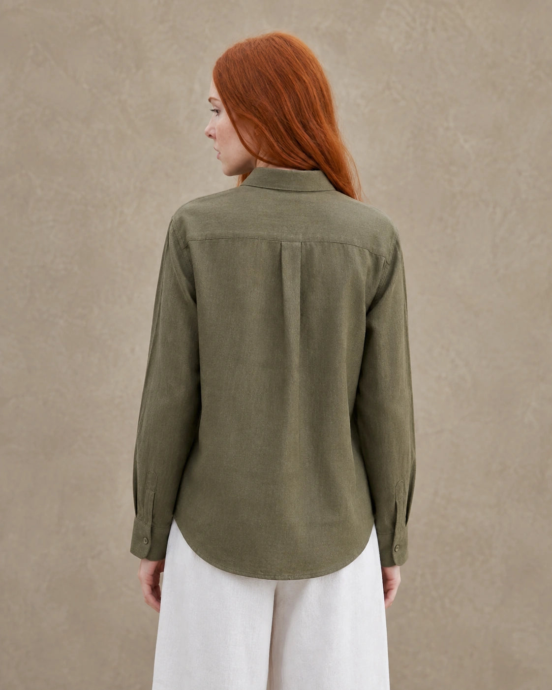 Achteraanzicht van een olijfgroen linnen blouse met getailleerde kraag en lange mouwen.