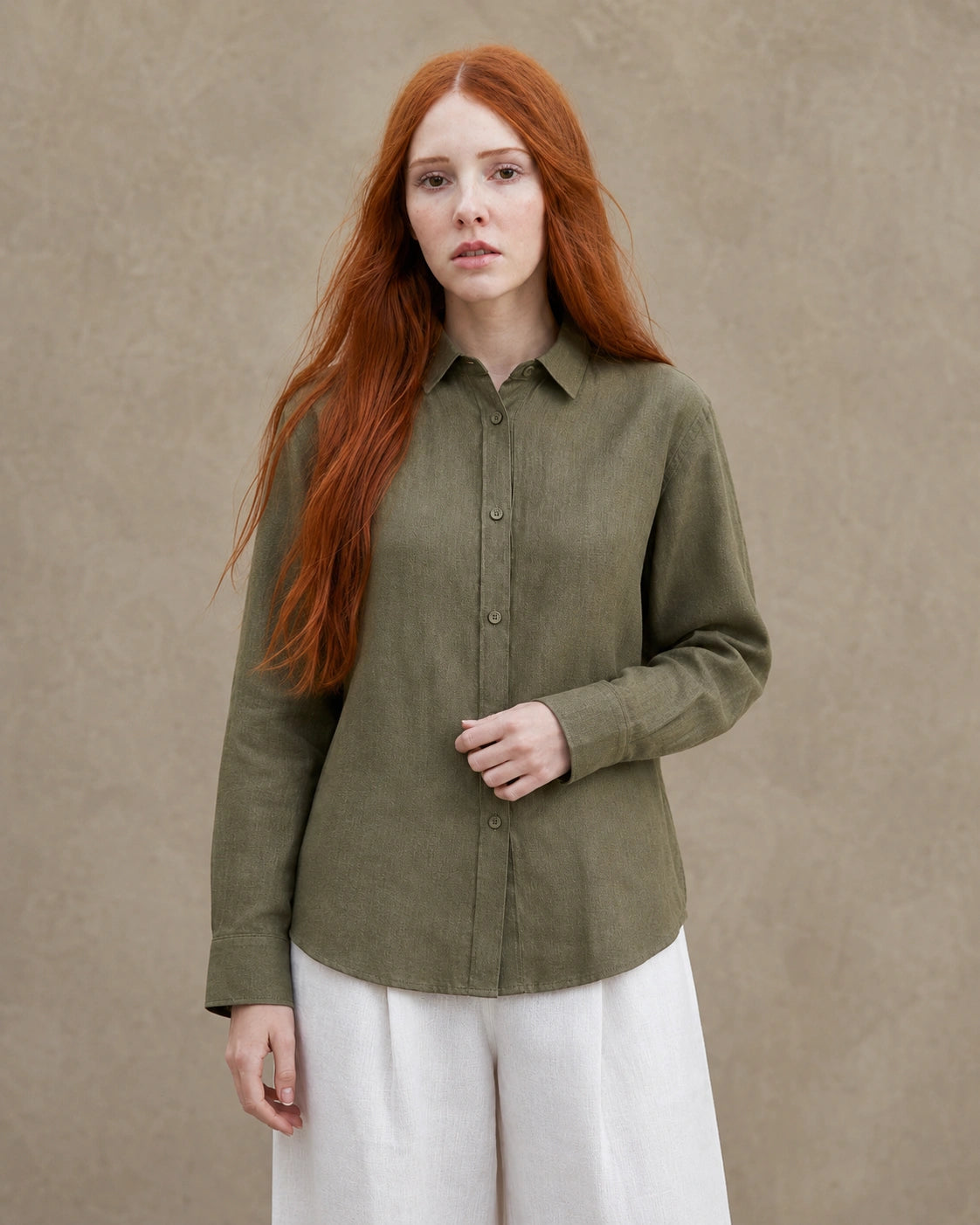Vrouw draagt een olijfgroen linnen blouse met getailleerde kraag en lange mouwen, vooraanzicht.
