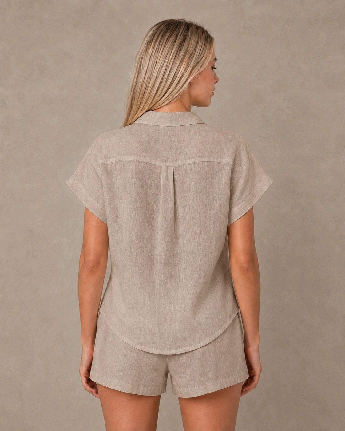 Achteraanzicht van een slank gesneden taupe linnen blouse met korte mouwen.