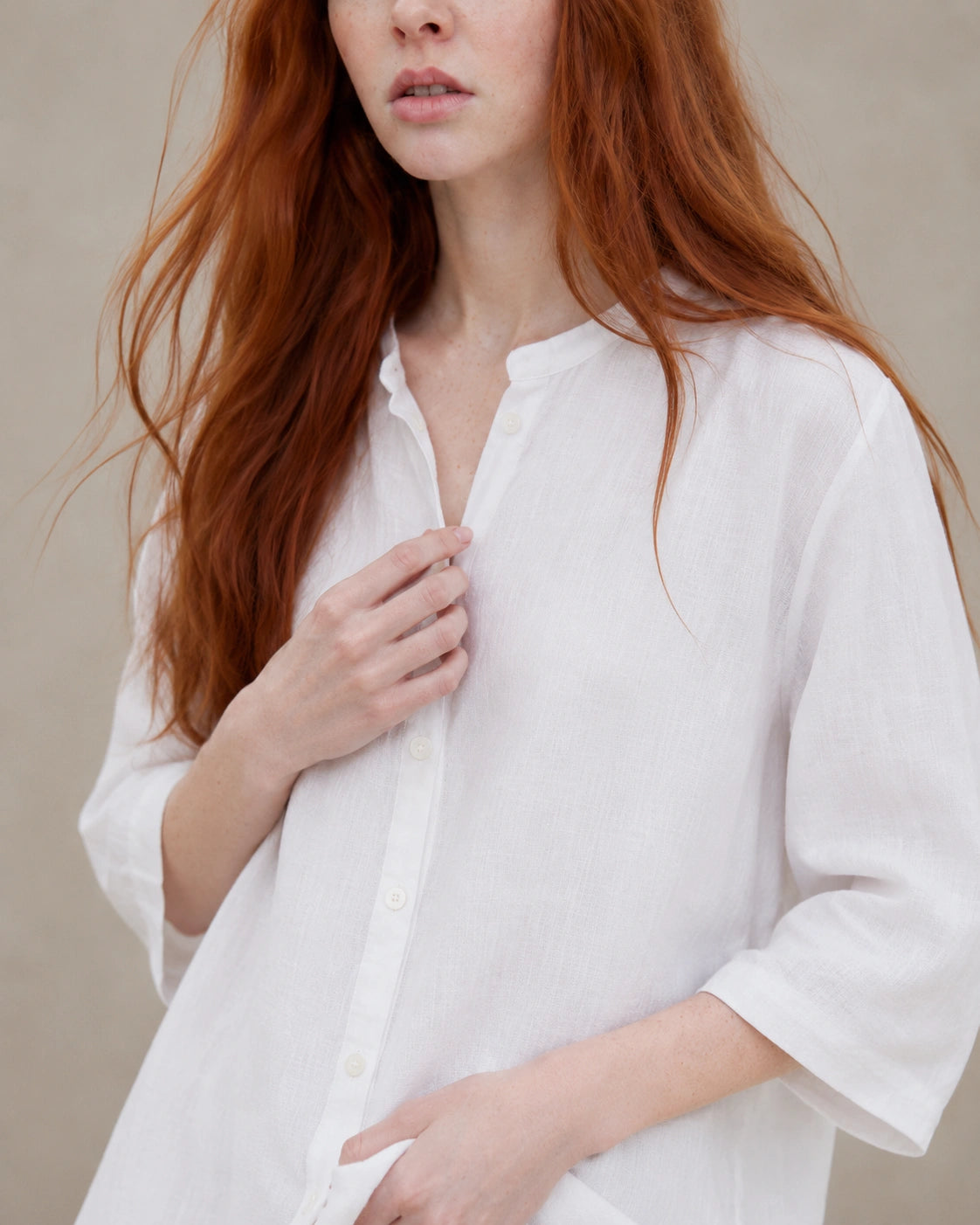 Close-up van het kleine open kraagje en de V-hals van een wit linnen blouse.