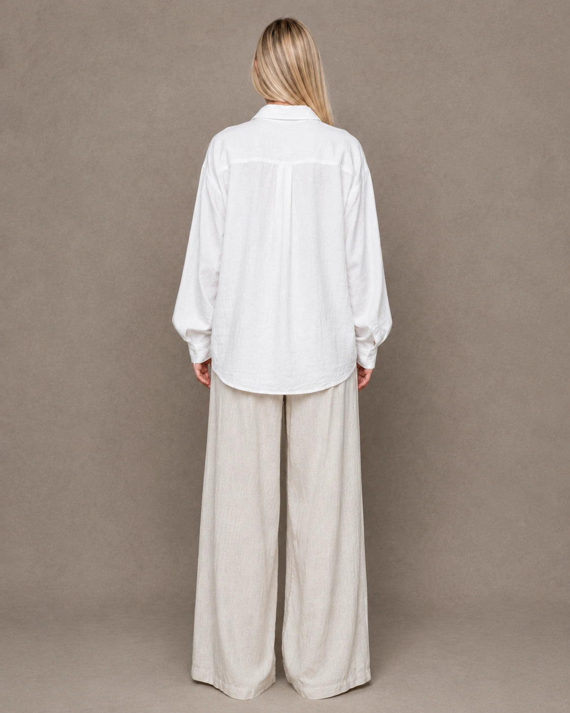 Back view of a white linen shirt with a polo collar and long sleeves.