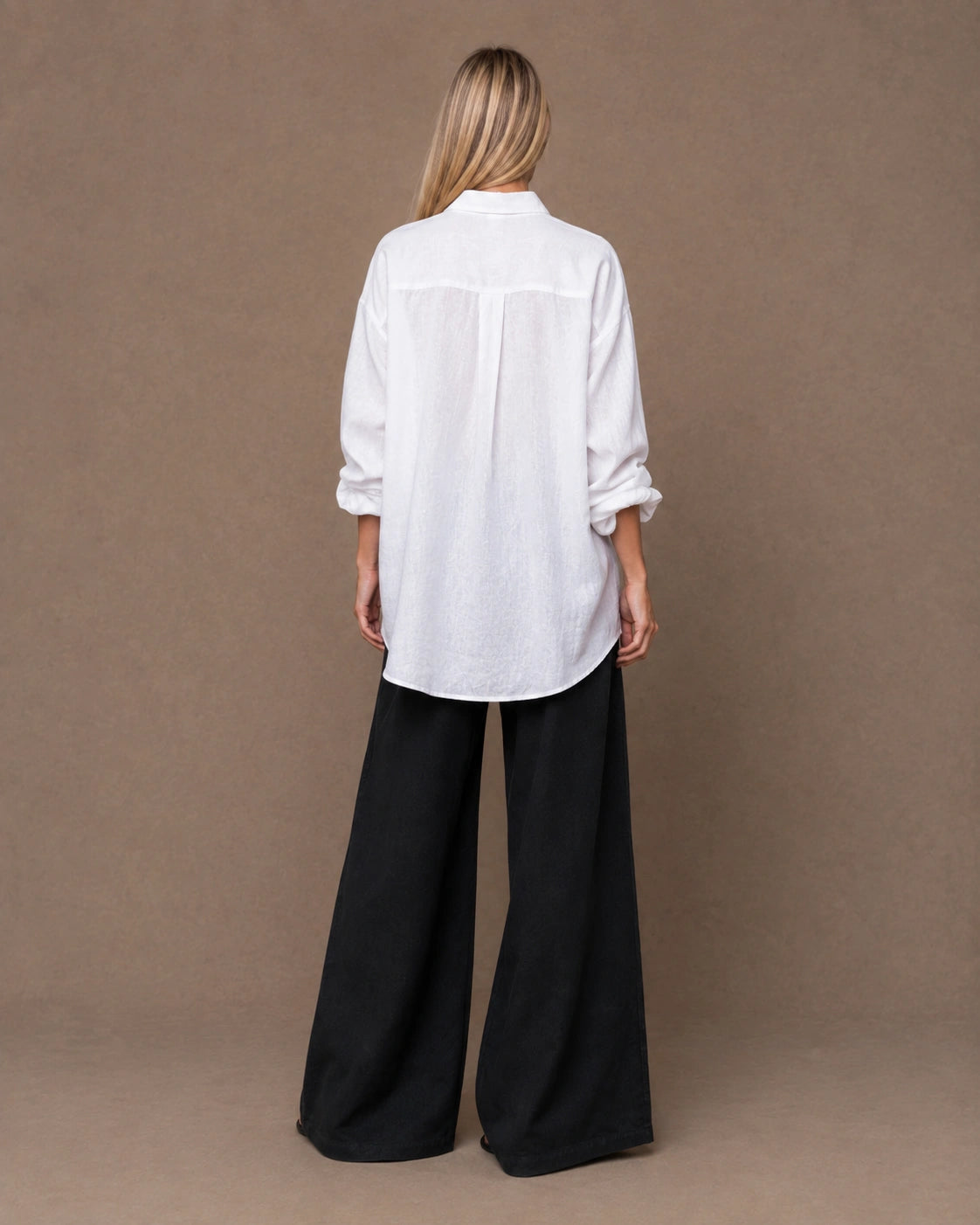 Achteraanzicht van een relaxte wit linnen blouse met lange mouwen.