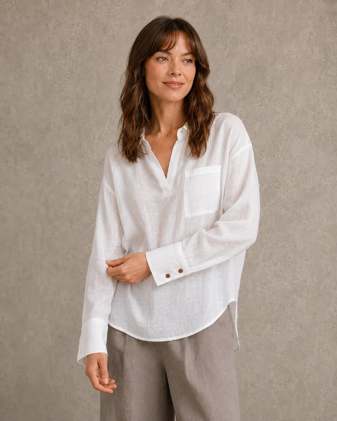 Vrouw draagt een wit linnen blouse met V-hals reverskraag en lange mouwen, vooraanzicht.