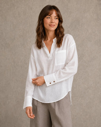 Vrouw draagt een wit linnen blouse met V-hals reverskraag en lange mouwen, vooraanzicht.