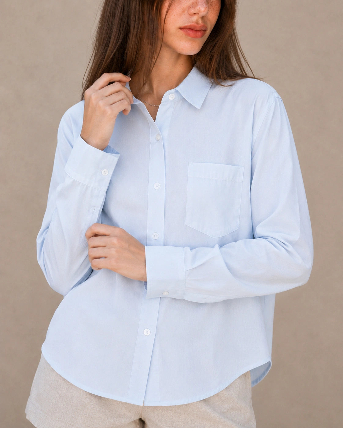 Close-up van de kraag en knopenlijst van een blauw tencel-linnen blouse.