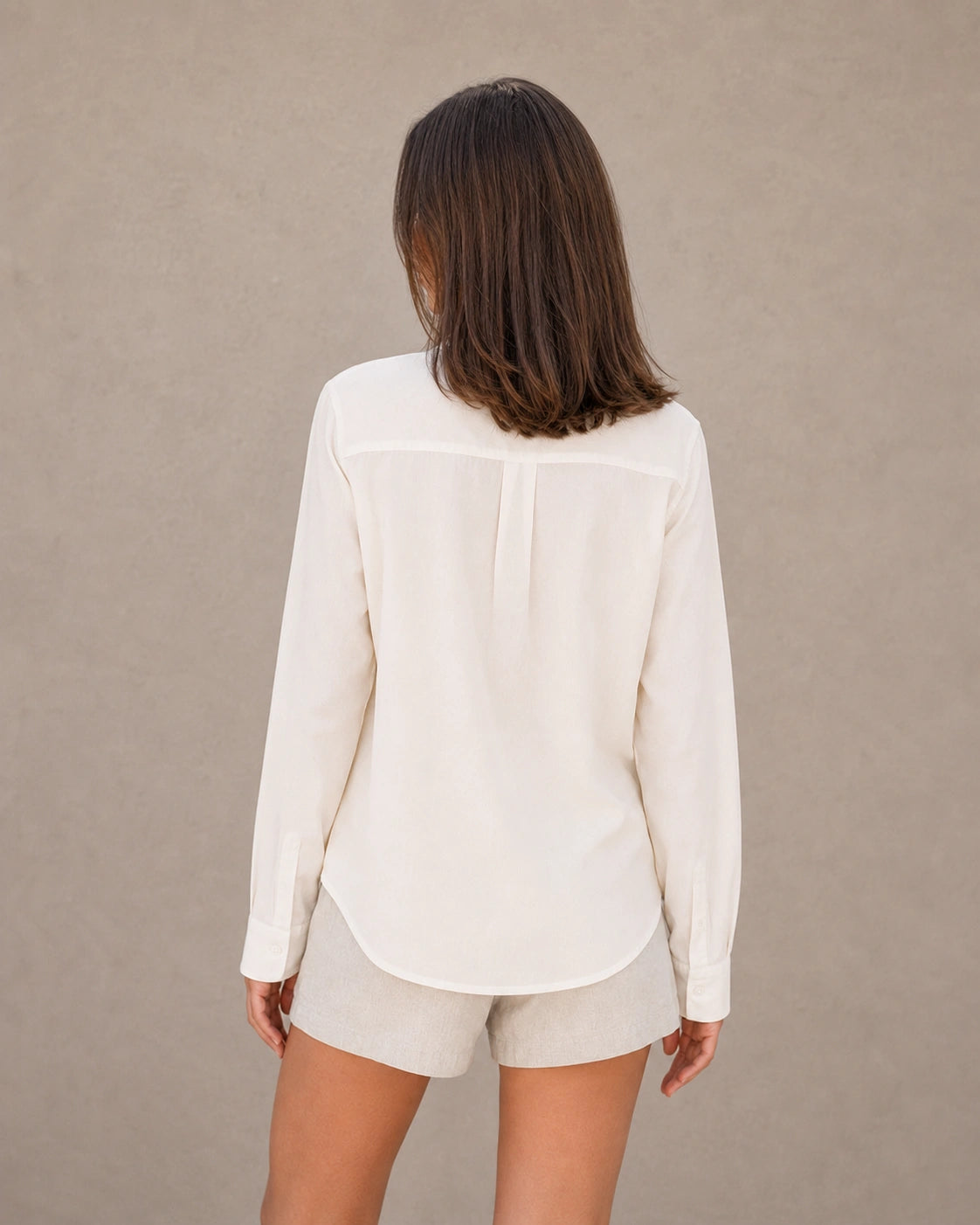 Achteraanzicht van een gebroken wit tencel-linnen doorknoopblouse met lange mouwen.