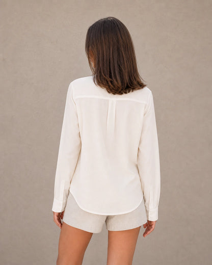 Achteraanzicht van een gebroken wit tencel-linnen doorknoopblouse met lange mouwen.