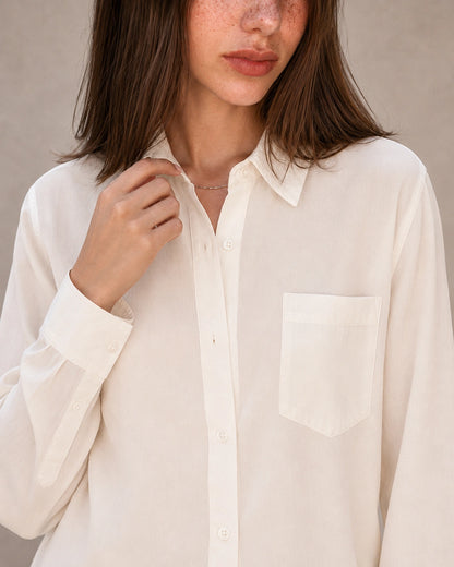 Close-up van de kraag en knopenlijst van een gebroken wit tencel-linnen blouse.