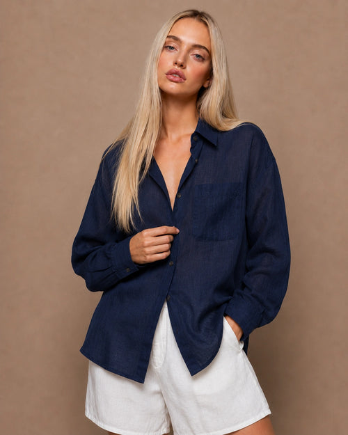 Vrouw draagt een marineblauw linnen-katoenen blousejasje met gestructureerde kraag, vooraanzicht.