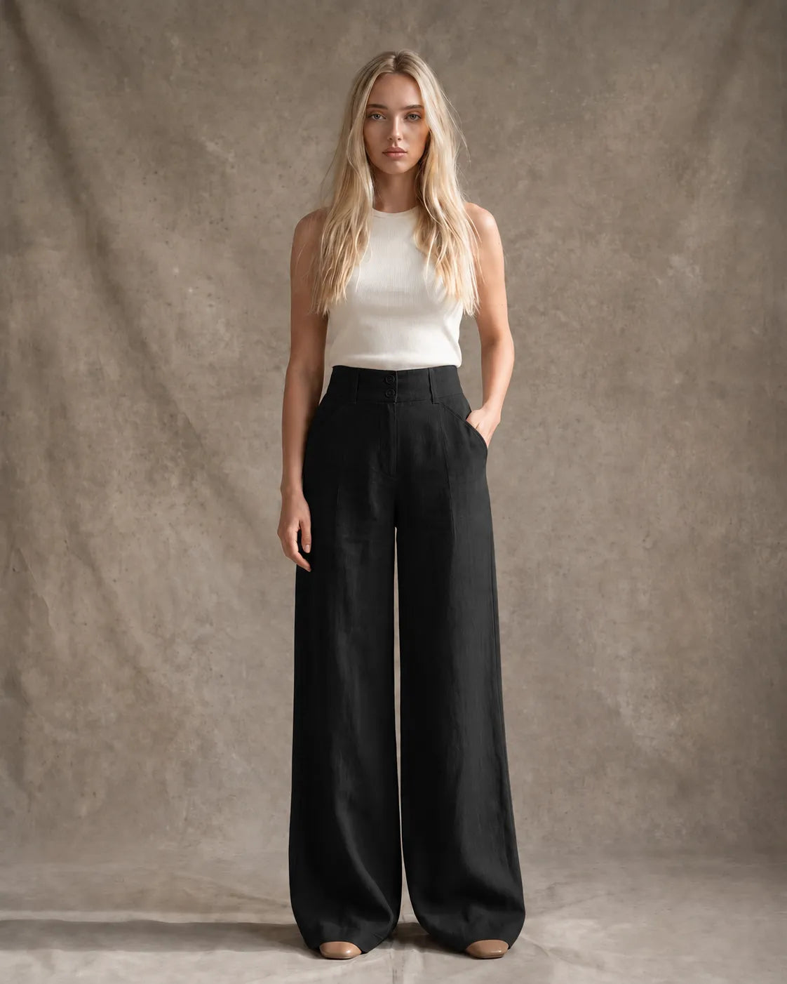 Model draagt een wijde broek dames in Black katoen-linnenmix met halfelastische taille en dubbele knoopsluiting, gestyled met een ivoorkleurig topje, vooraanzicht.