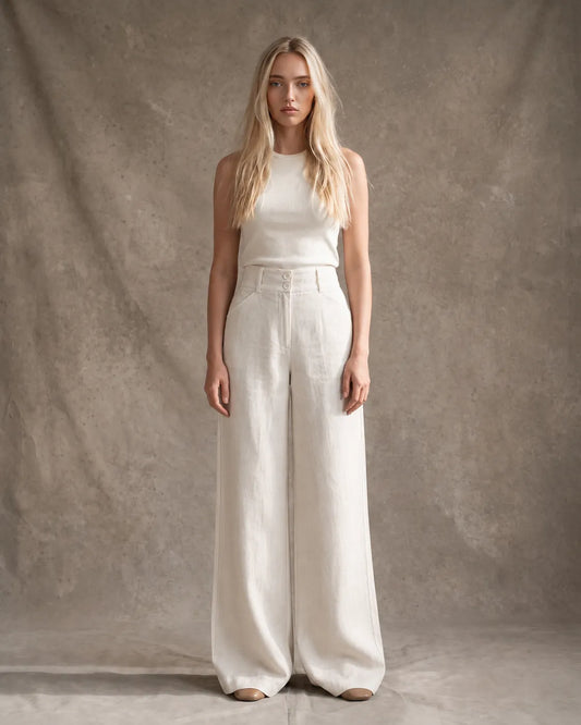 Model draagt een wijde broek dames in Hemp katoen-linnenmix met halfelastische taille en dubbele knoopsluiting, gestyled met een ivoorkleurig topje, vooraanzicht.