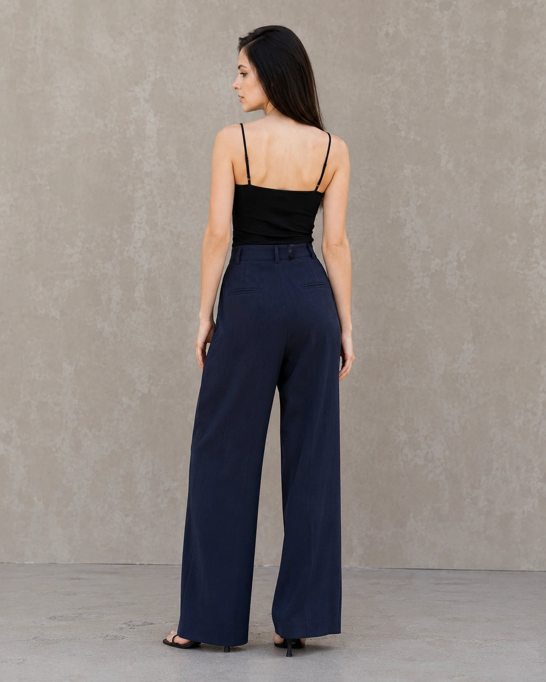 Achteraanzicht van model in een marineblauwe wijde broek dames in katoen-linnenmix met steekzakken.