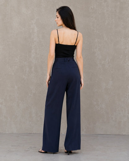 Achteraanzicht van model in een marineblauwe wijde broek dames in katoen-linnenmix met steekzakken.