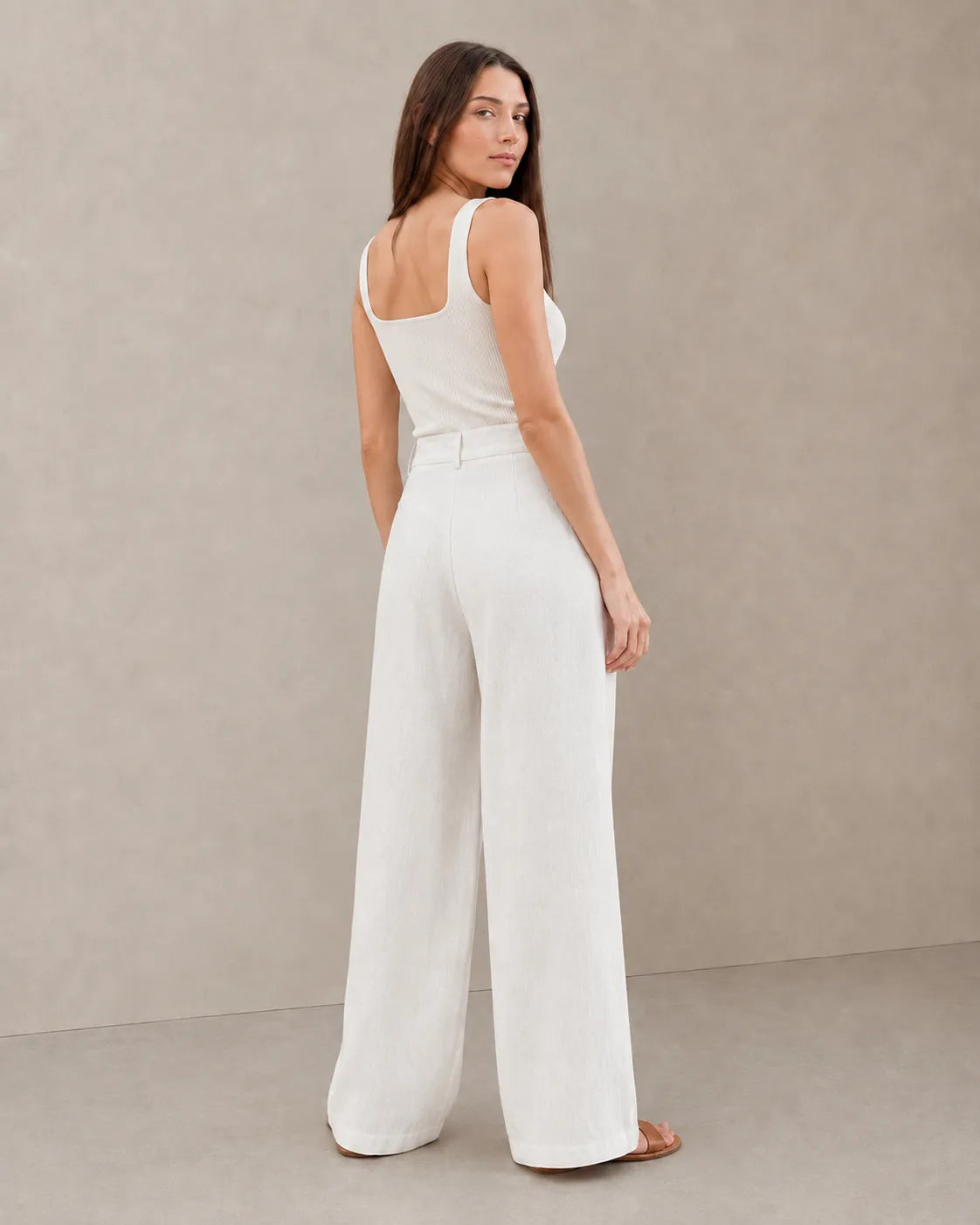 Back view of model wearing white wide-leg summer trousers in a cotton-linen-polyester blend.