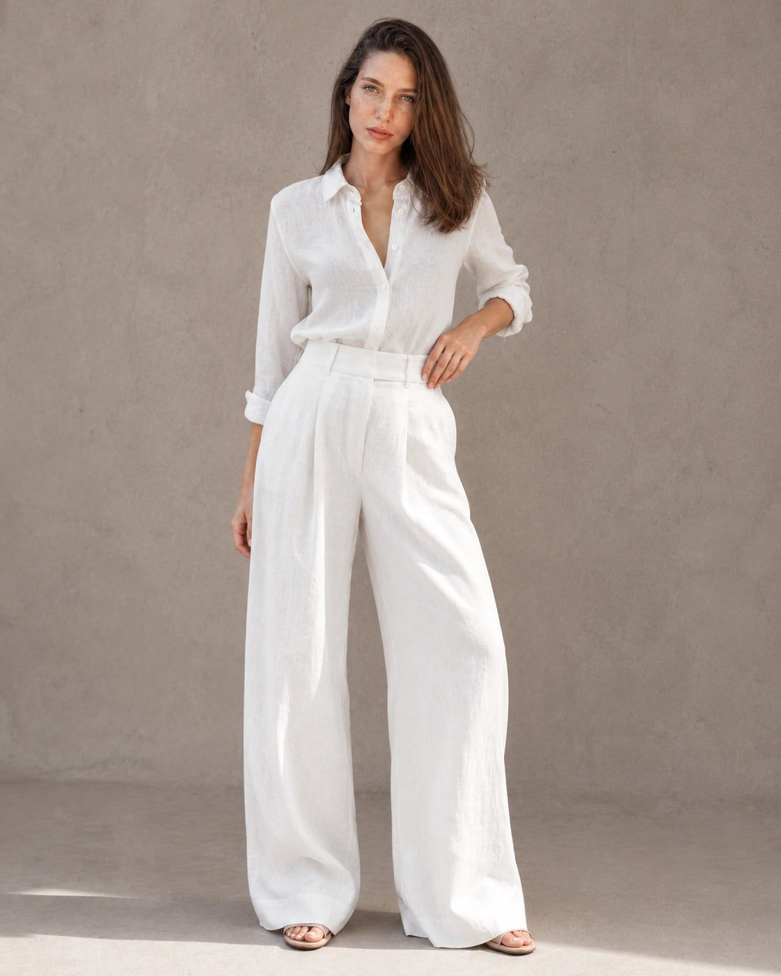 Model draagt een wijde broek dames in witte katoen-linnenmix met hoge elastische taille, gestyled met een bijpassend wit linnen overhemd, vooraanzicht.