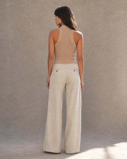 Achteraanzicht van model in een enkellange linnen broek dames in gebroken wit met flapzakken.
