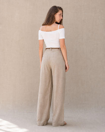 Achteraanzicht van model in een kaki linnen broek dames met rechte pijp, hoge taille en gevlochten riem.