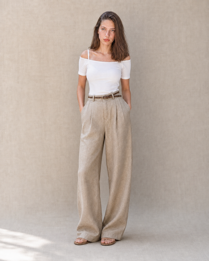 Model in een kaki linnen broek dames met rechte pijp en een hand in de zak, vooraanzicht, met zicht op de rechte lijn tot aan de zoom.